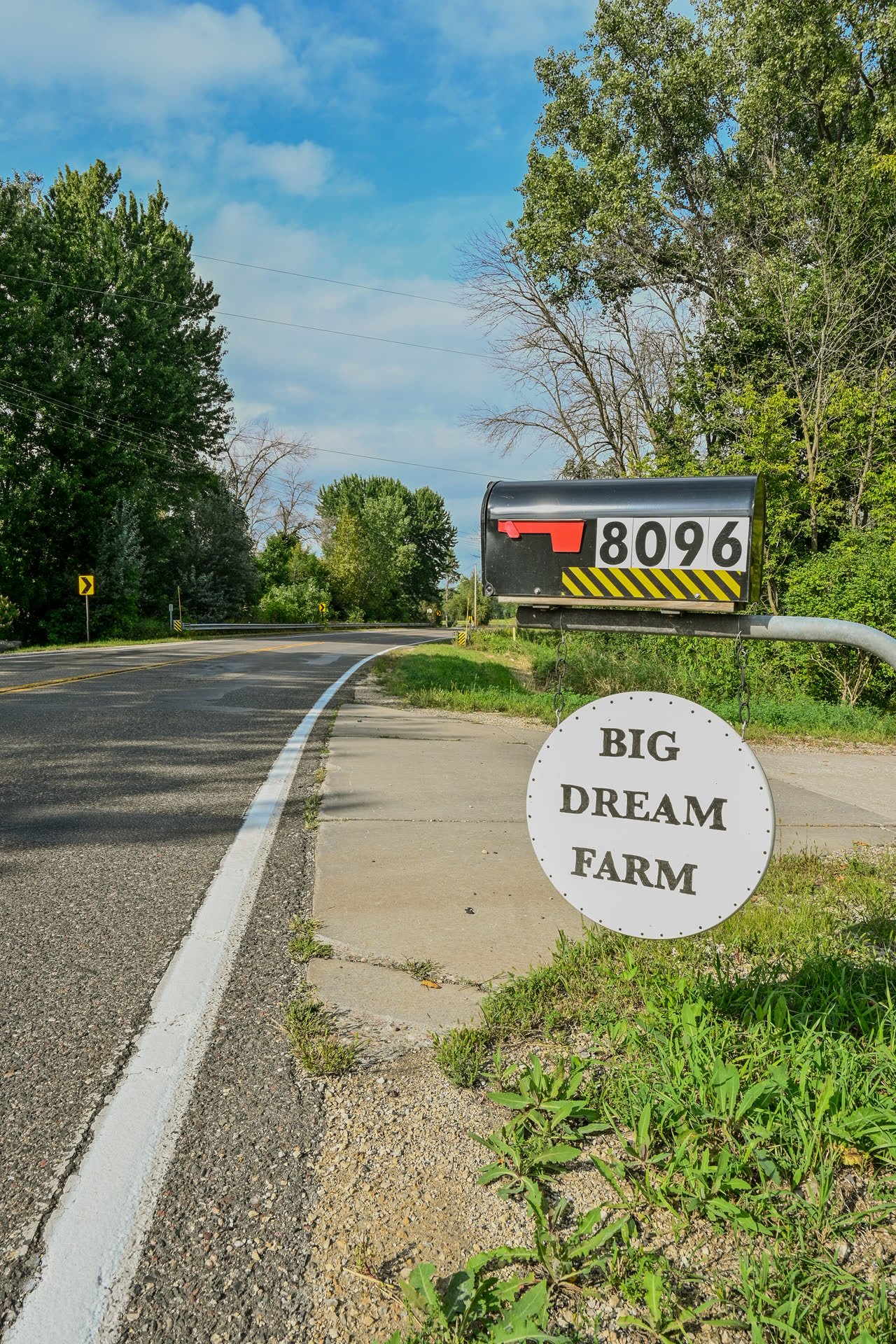 Roadside mailbox numbered 8096 with a round white Big Dream Farm sign mounted beneath it